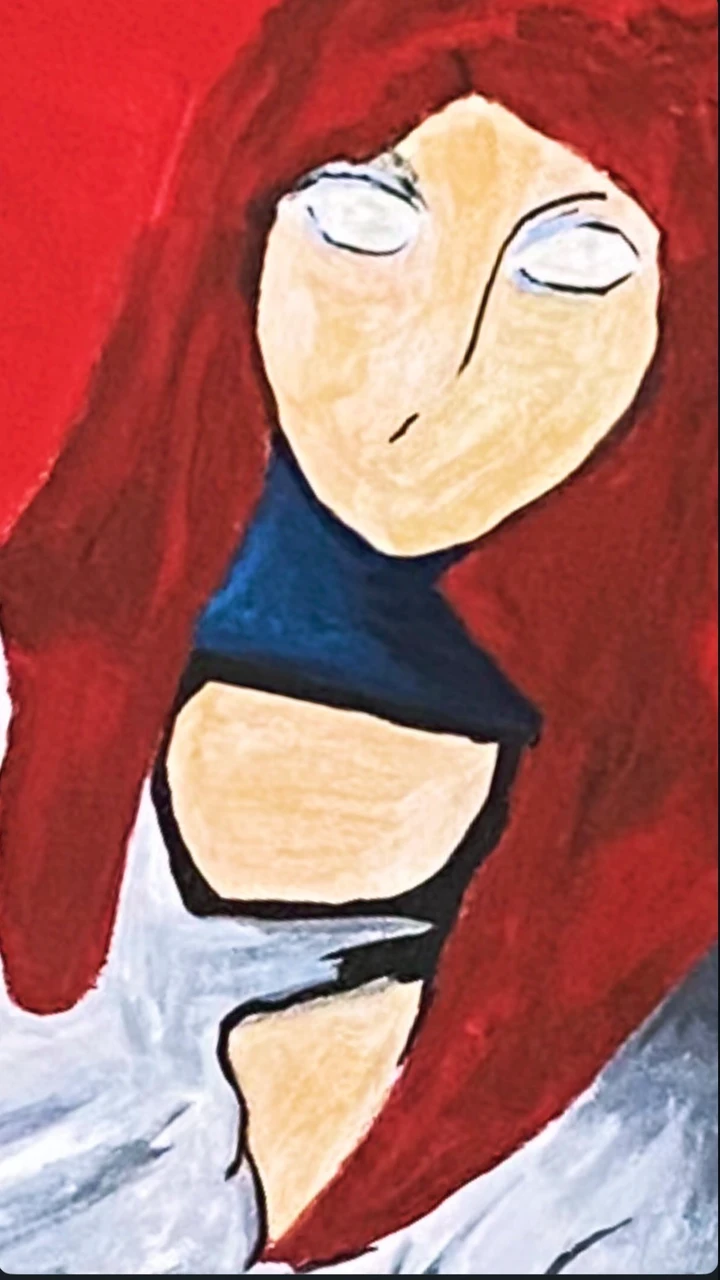 A close view of the painted doll’s face and red hair